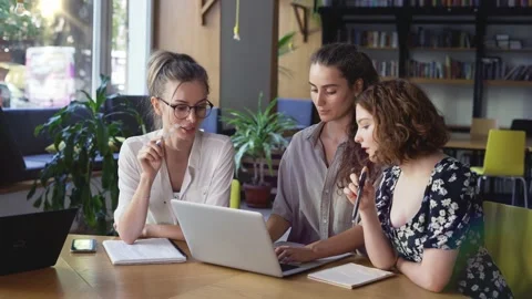 Three mature students discussing new project, making notes with laptop Stock Footage 160796434