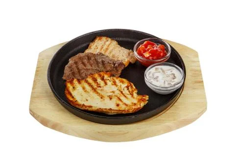 Three meat steaks with sauce on pan, isolated white Stock Photos