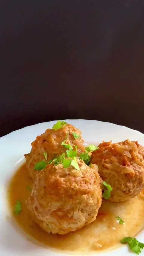 Three meatballs in sauce being garnished with fresh parsley Video stock 331974542