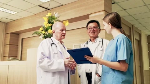 Three medical professionals, including doctors and nurse, standing in hospital. 動画素材 312821750