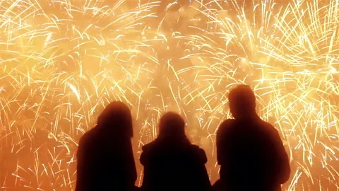 Three Of Men Against The Bursting Wall Of Dazzling Fireworks At Night Stock Footage 97448637