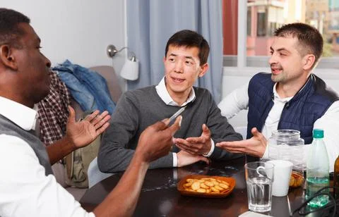 Three men are drinking beer and talking about life in time rest together Stock-Fotos