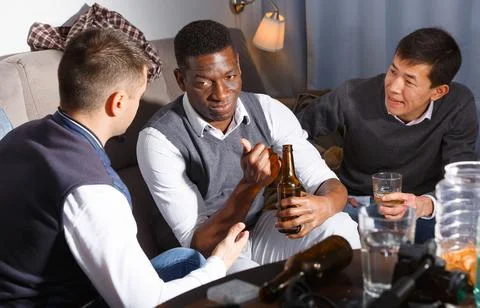 Three men are drinking beer and talking about life in time rest together Foto stock