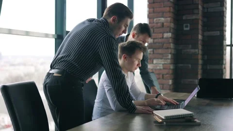 Three Men Collaborating on a Laptop in a Modern Office Setting During Daytime Stock Footage 305405948