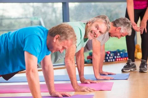 Three men doing press-ups at the gym Fotos Stock