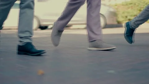 Three men dressed in suits and elegant shoes walk in the daytime. Stock Footage 239152294