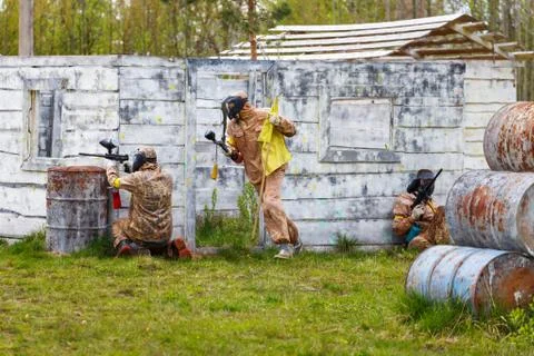 Three men in dynamic situation with paintball flag Stock Photos