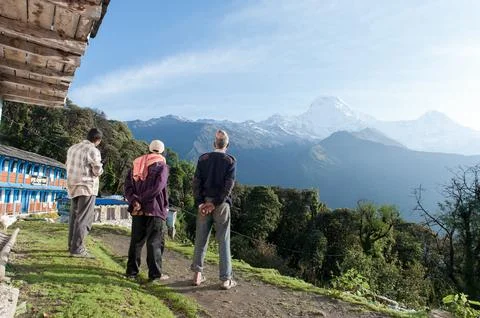 Three Men Looking Towards Fishtail Mountain, Annapurna Base Camp, Nepal Stock Photos