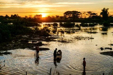 Three men on the Mekong river at sunset Stock Photos