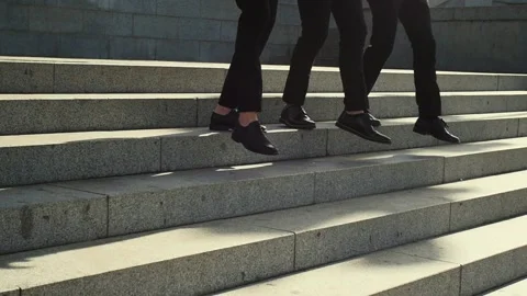 Three men in shoes go down the stairs Stock Footage 131310881