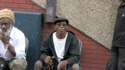 Three men sit outside a Caribbean kiosk selling traditional herbs Video stock 10750554