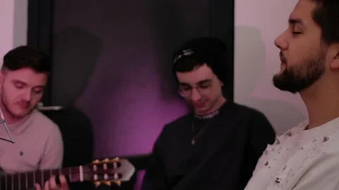 Three men sit, sing, play guitar. Recording studio, professional singers Stock Footage 194026503