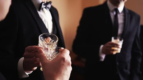 Three men in suits drink whiskey in a bar. Stock Footage 129084620