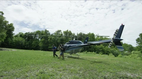 Three men walking away from helicopter Stock Footage 63052833