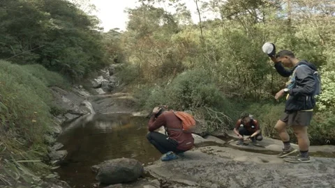 Three men wash their faces in the river, at the end camera looking another view Stockbeeldmateriaal 152787902