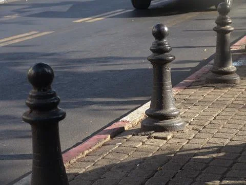 Three metal posts on a paved sidewalk urban view in daylight 写真素材