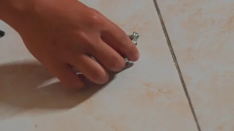 Three Metal Screws on Tiled Floor Stock Footage 312479712