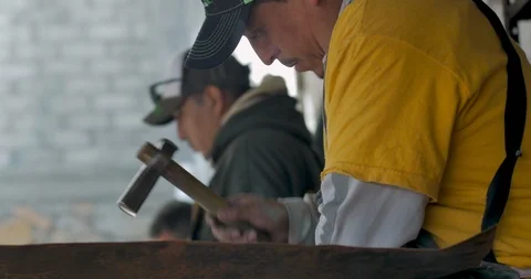 Three Mexican or Hispanic men working in a factory pounding copper with a hammer Stock Footage 102722503