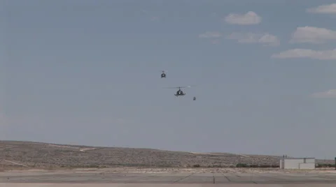 Three military helicopters approach the camera to land Stock Footage 45558085