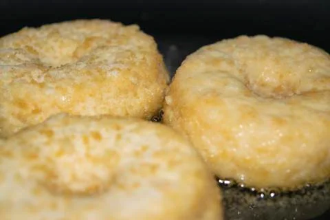 Three minced chicken cutlets are fried in a pan in vegetable oil. Close up. Stock Photos