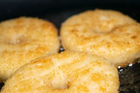 Three minced chicken cutlets are fried in a pan in vegetable oil. Close up. Stock Photos
