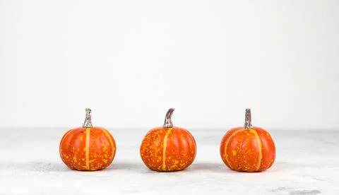 Three mini pumpkins against white background. Thanksgiving or harvest concept Stock Photos