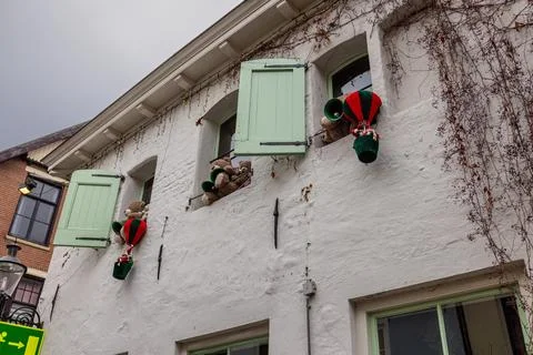 Three mint shuttered windows display teddy bears peeking and floating in balloon Stock Photos