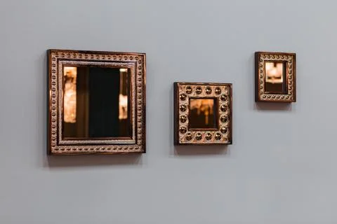 Three mirror frames on grey wall. Triptych scenery frames mirrored golden cop Stock Photos