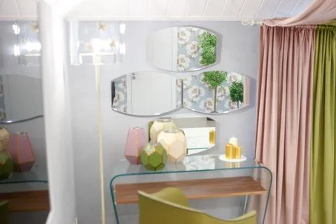 Three mirrors hang on the wall by the bedside table. Stock Photos