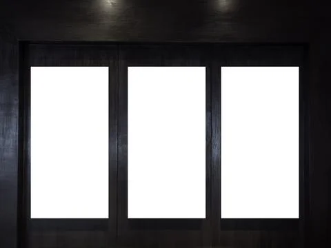 Three mockup vertical rectangle painting frames hanging on dark wood wall bac Stock Photos
