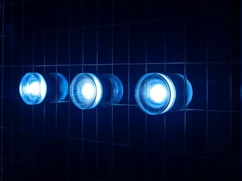 Three modern round blue light lamps, circle shape mounted on striped grid p.. 写真素材