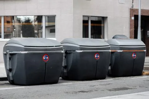 Three modern waste bins lined up on a city street, showcasing sleek design .. 스톡 사진