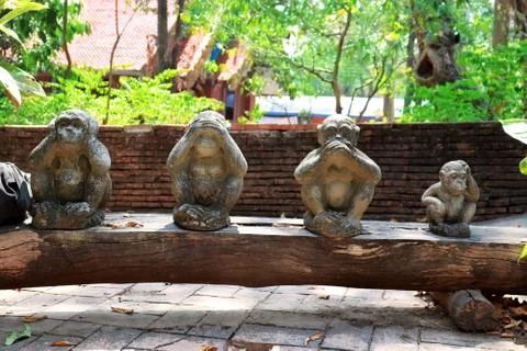 Three monkey statue sit on nature background and hand small statues with the  Stock Photos