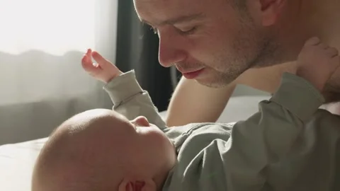 Three month old baby boy playing with father close up. Tender family morning in Stock Footage 312290262