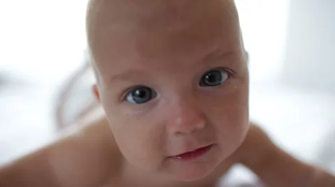Three months baby lying on white bed and tries to crawl Stock Footage 41381996