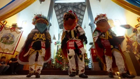 Three Moors dancers perform Saint Santiago ritual before decorated church altar Stock Footage 345344874