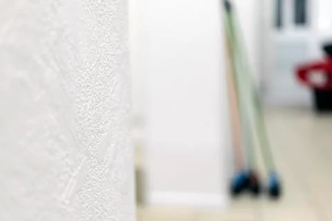 Three mops of different colors stand near the wall 스톡 사진
