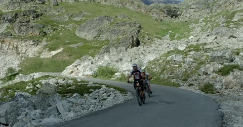 Three mountain bikers ride fast down a mountain road. Stock-Footage 78030676