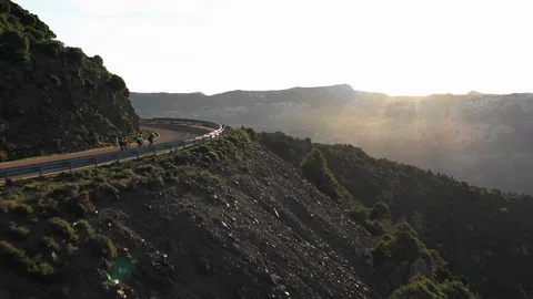 Three mountain bikers riding on the mountain road at dusk Stock-Footage 102190136