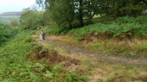 Three mountain bikers very fast down a wet trail , drone aerial 4K Stock Footage 101108010