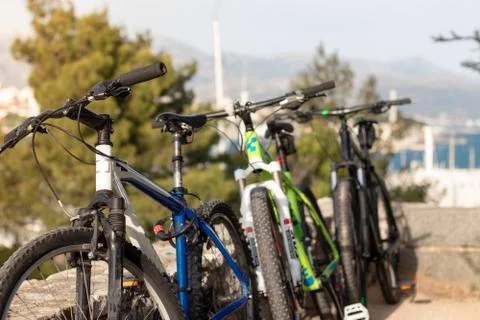 Three mountain bikes standing leaned on a wall, blue green and black one. Fri Stock Photos
