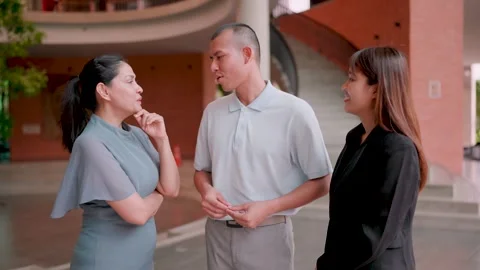Three multi-Asian co-workers standing in the hallway in the office talking, info Stock Footage 265229215
