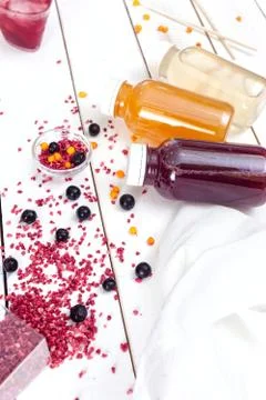 Three multi-colored bottles with fruit drink on a white board. View from abov Stock Photos