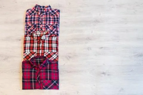 Three multi-colored checkered women's shirts lying neatly folded Stock Photos