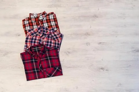 Three multi-colored checkered women's shirts lying neatly folded Stock Photos