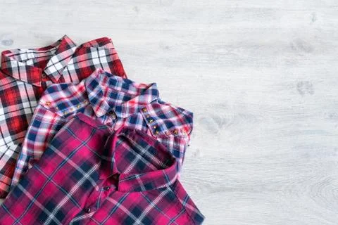 Three multi-colored checkered women's shirts lying neatly folded Stock Photos