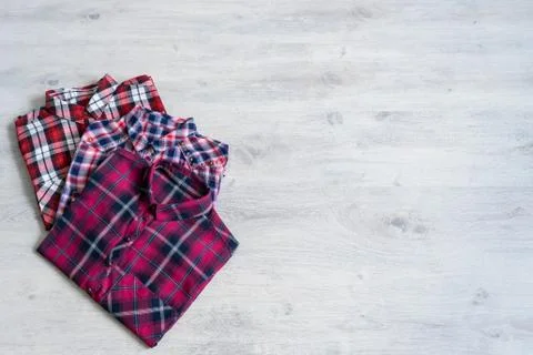 Three multi-colored checkered women's shirts lying neatly folded Stock Photos