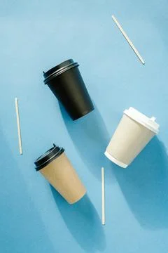 Three multi-colored paper cups for coffee and wooden sticks for mixing sugar Stock Photos