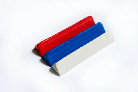 Three multi-colored plasticine bars on a white background. Stock Photos
