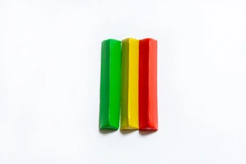 Three multi-colored plasticine bars on a white background. Фото